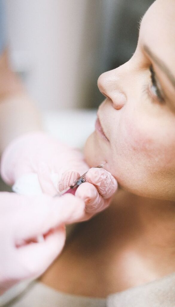 Woman receiving a cheek dermal filler injection